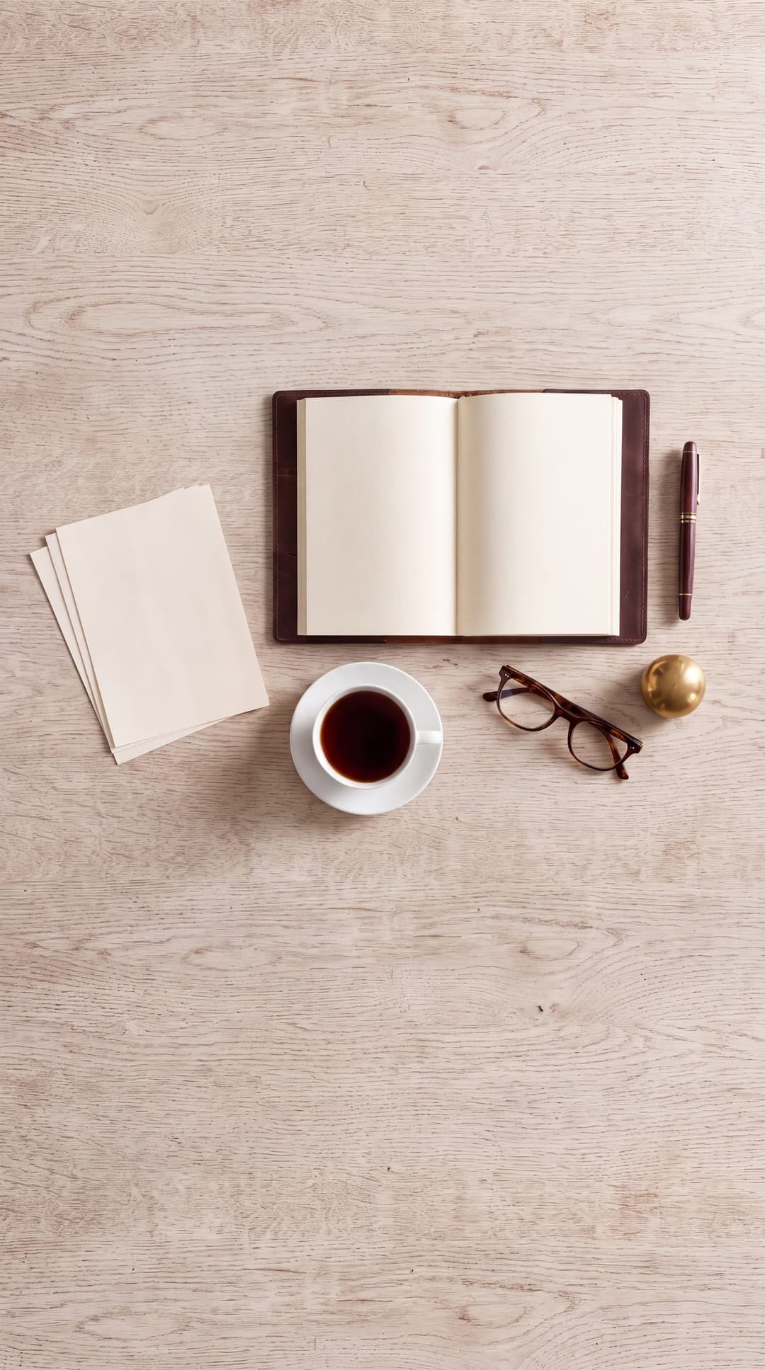 A writing desk in morning light, a notebook open and a cup of tea